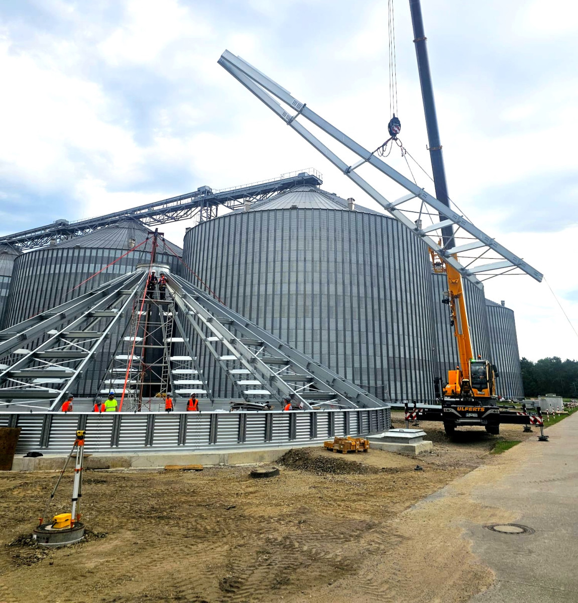 Crane lifting the roof structure on a silo assembly site — Rosilo